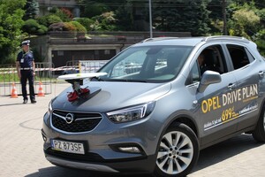 Zdjęcie przestawia samochód osobowy, którym policjanta ruchu drogowego pokonuje tor konkursowy.
