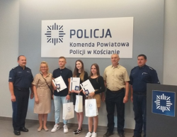 Na zdjęciu widoczny I Zastępca Komendanta Powiatowego Policji w Kościanie, Naczelnik Wydziału Prewencji KPP w Kościanie wraz z nastolatkami i ich rodzicami.