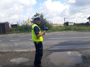 Zdjęcie przestawia policjanta pełniącego nadzór nad bezpieczeństwem na drodze.