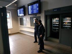 Na zdjęciu widać dwóch policjantów umundurowanych w budynku dworca PKP.