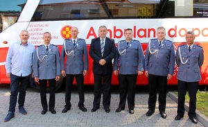 Zdjęcie przedstawia 7 mężczyzn stojących na tle krwiobusa.