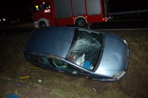 samochód osobowy z uszkodzoną przednią szybą, stojący na ścianie przydrożnego rowu