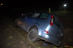 tył samochodu osobowego, stojącego na pochyłem poboczu drogi